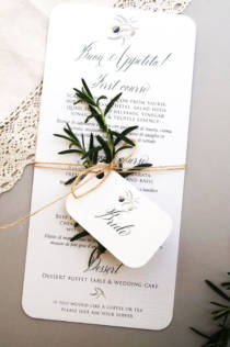 An italian wedding place name card and menu with a sprig of rosemary tied in a bundle