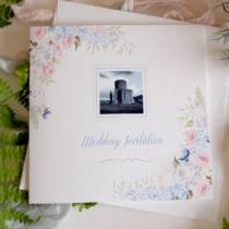 a wedding invitation with a summer floral display