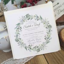 A rustic wedding invitation with a spring wreath design